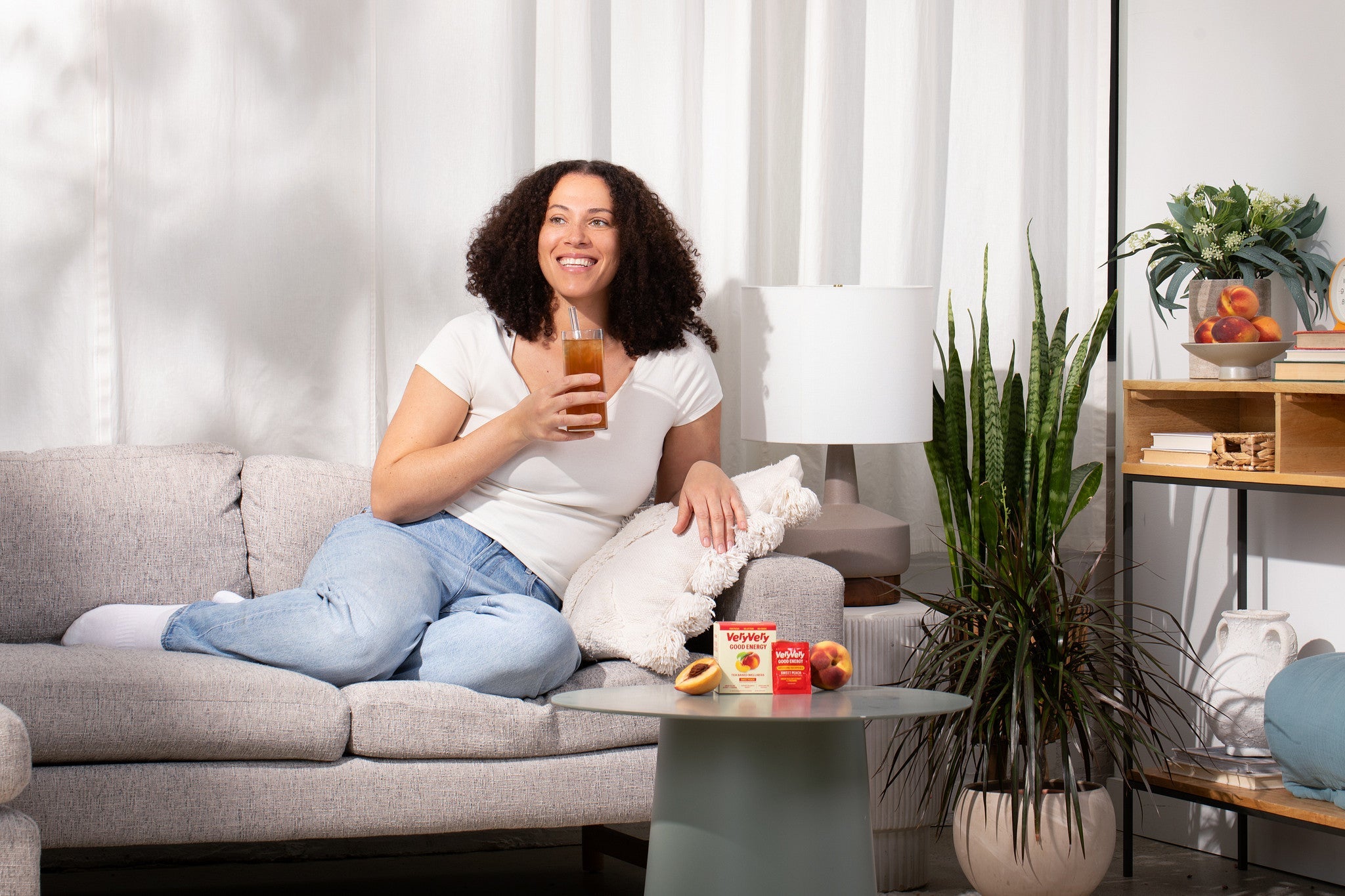 Peach | Energizing Tea — Model enjoying iced tea on couch