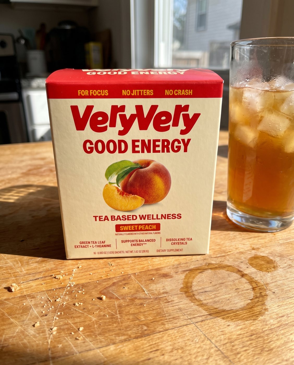 A customer's box of Good Energy and a glass of iced tea on a kitchen table