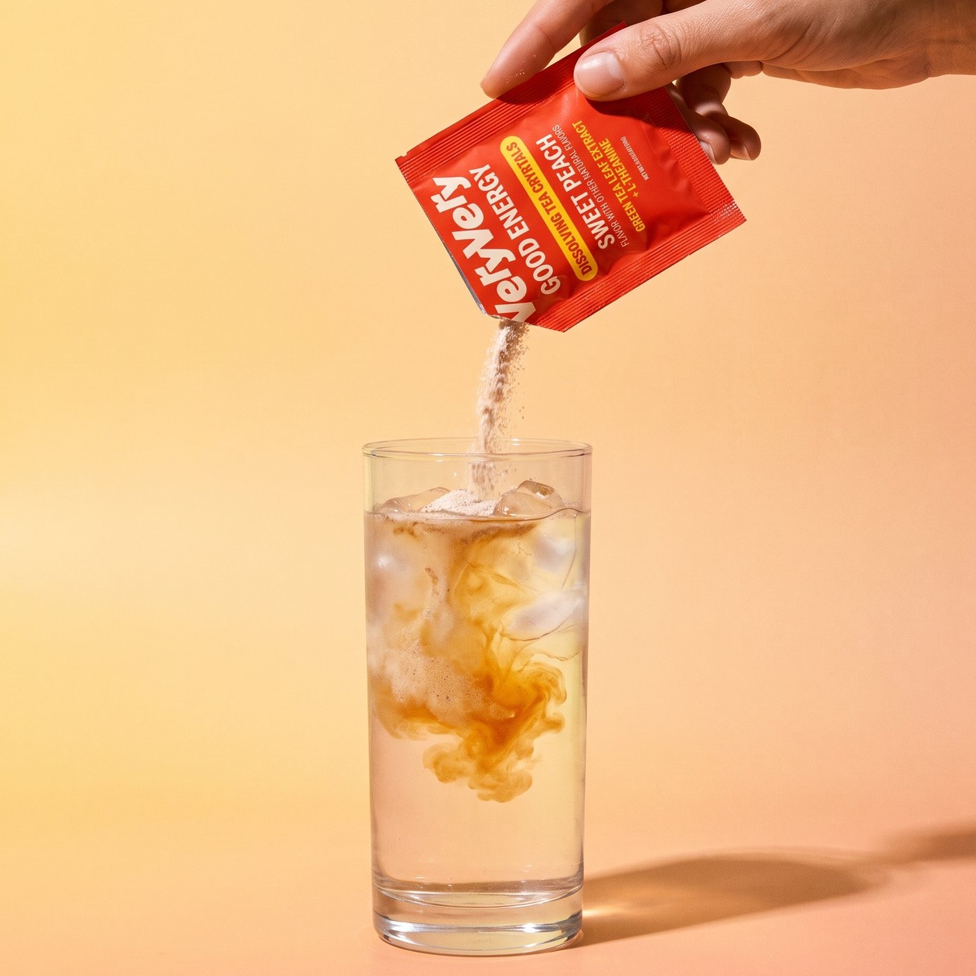 Pouring a VeryVery sachet into a glass of iced water